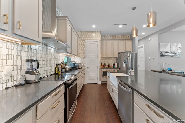 kitchen with hanging light fixtures, dark hardwood / wood-style floors, stainless steel appliances, tasteful backsplash, and wall chimney exhaust hood