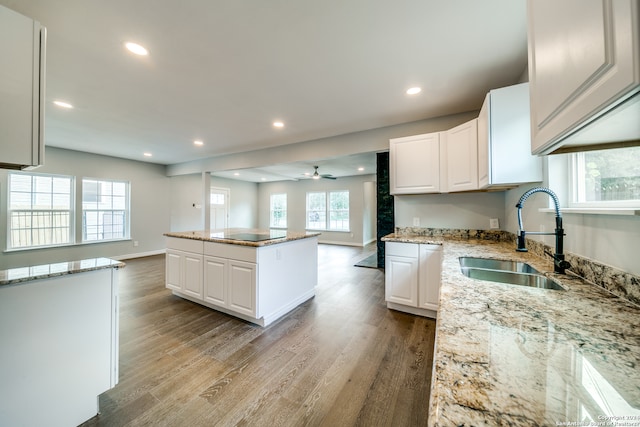 kitchen featuring white cabinets, ceiling fan, sink, and light hardwood / wood-style floors