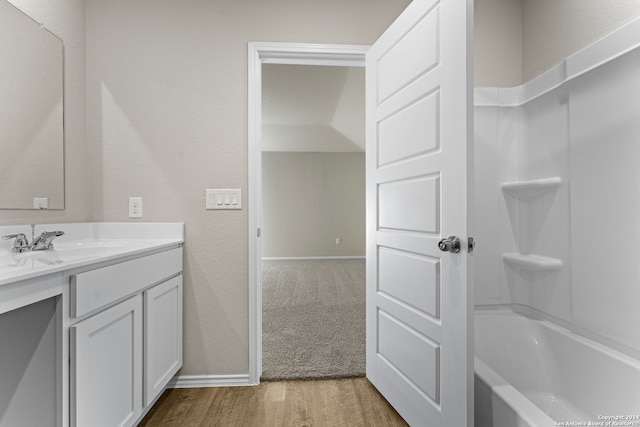 bathroom with bathtub / shower combination, wood-type flooring, and vanity