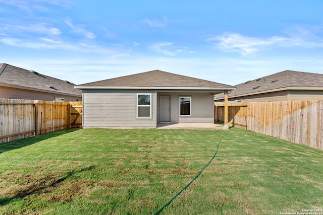 rear view of house featuring a patio area and a yard