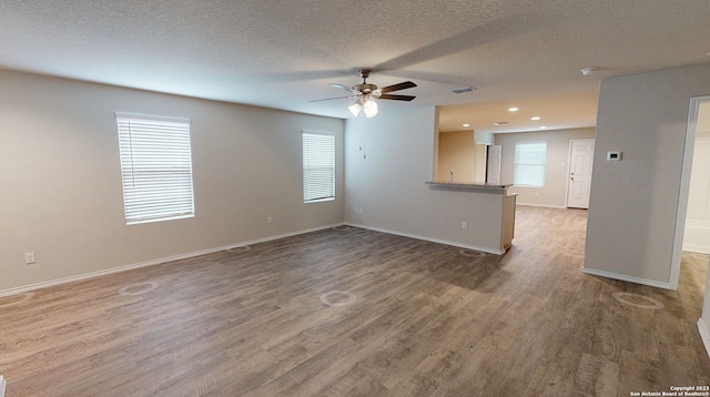 unfurnished room with ceiling fan, dark hardwood / wood-style flooring, and a textured ceiling