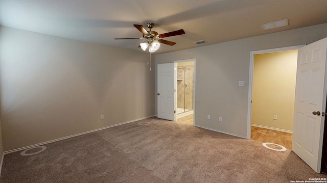 unfurnished bedroom featuring ceiling fan, light colored carpet, and ensuite bathroom