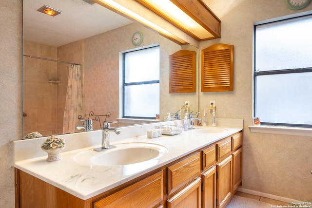 bathroom with tile floors, dual sinks, and vanity with extensive cabinet space