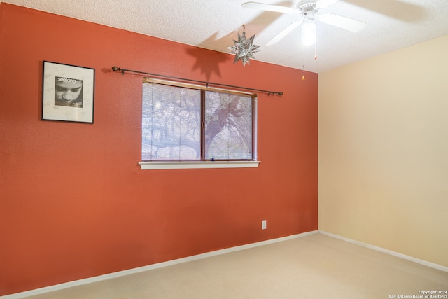 carpeted empty room featuring ceiling fan and a textured ceiling