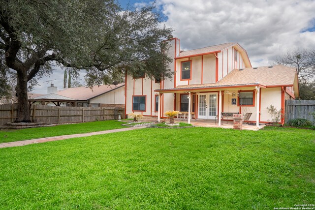 back of property featuring a lawn and a patio area