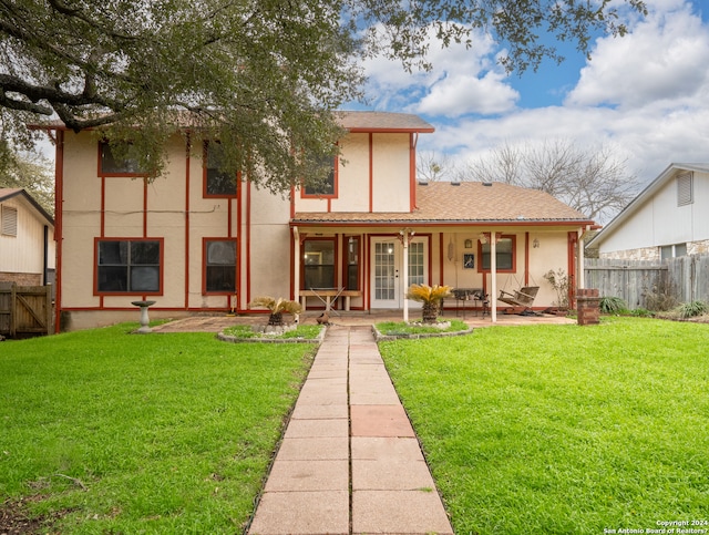 back of property with french doors and a lawn