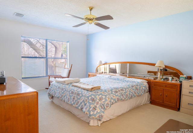 carpeted bedroom with a textured ceiling and ceiling fan