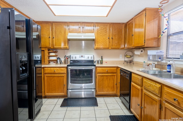 kitchen featuring sink, light tile floors, and black appliances