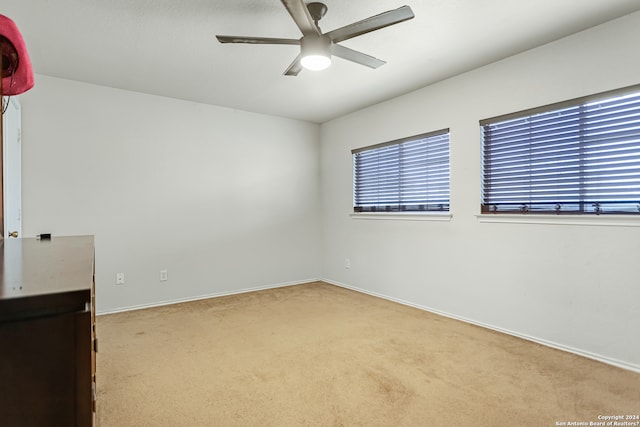 carpeted empty room with a healthy amount of sunlight and ceiling fan