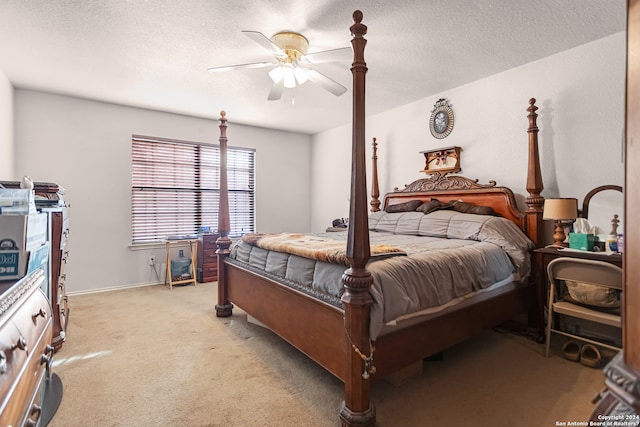 bedroom featuring a textured ceiling, ceiling fan, and light colored carpet