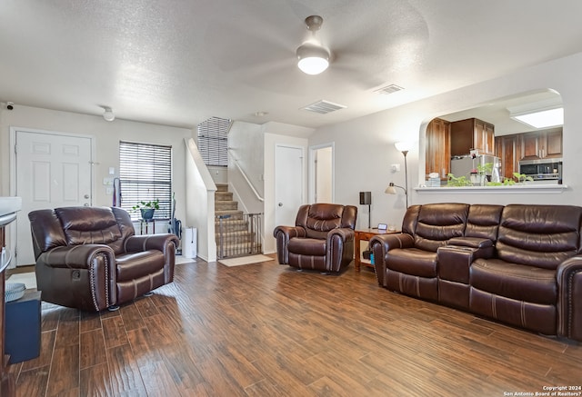 living room featuring a textured ceiling, hardwood / wood-style flooring, and ceiling fan