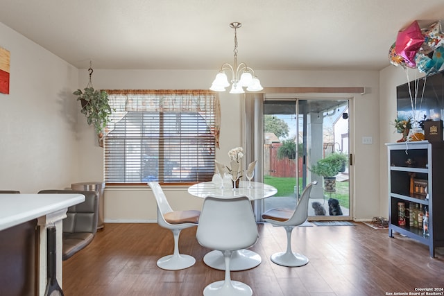 dining area with hardwood / wood-style flooring, plenty of natural light, and a chandelier