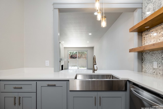 kitchen with gray cabinetry, hanging light fixtures, dishwasher, and sink