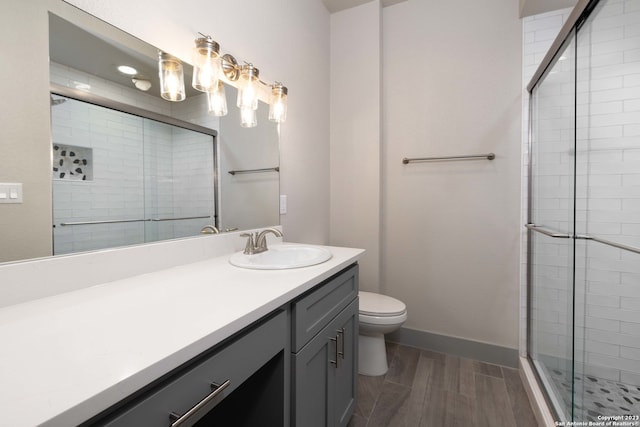 bathroom featuring toilet, vanity with extensive cabinet space, and walk in shower