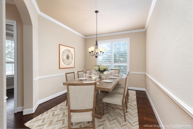 dining space with ornamental molding, a notable chandelier, and dark wood-type flooring