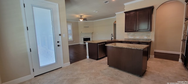 kitchen with backsplash, light stone countertops, ornamental molding, and ceiling fan