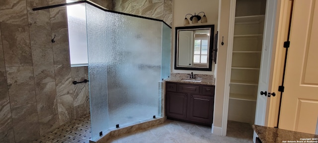 bathroom with tile flooring, walk in shower, and oversized vanity