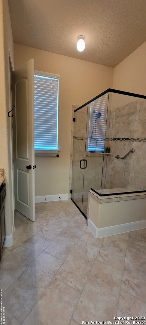 bathroom with a textured ceiling, vanity, and tile flooring