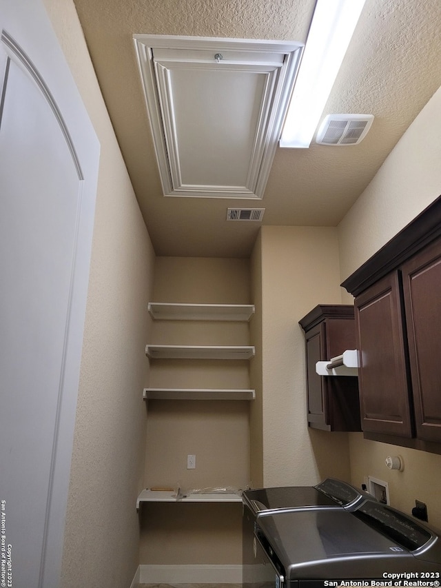 clothes washing area with washer hookup, cabinets, and washer and dryer