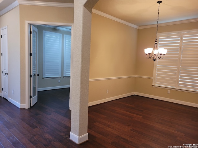 empty room featuring a chandelier, ornamental molding, and dark wood-type flooring