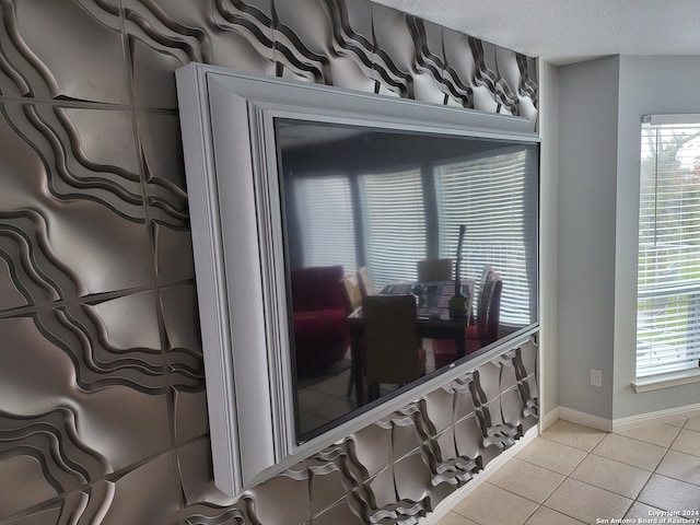 tiled dining area featuring a textured ceiling and a healthy amount of sunlight