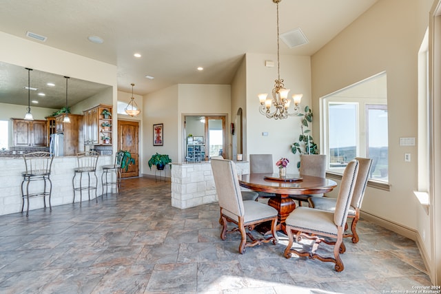 dining space featuring tile flooring, a chandelier, and a wealth of natural light