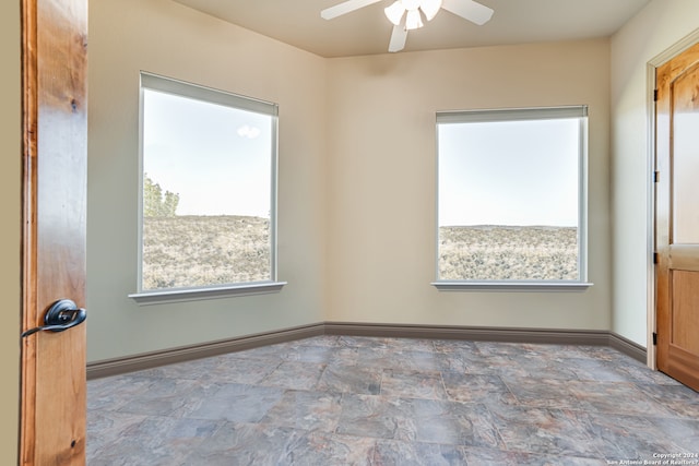 tiled empty room featuring ceiling fan