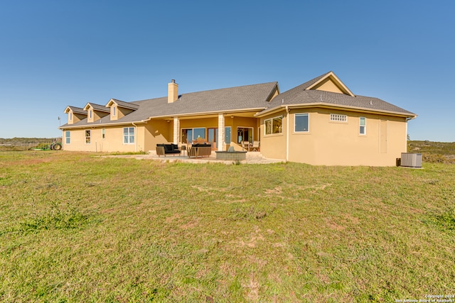 back of house featuring a lawn, a patio, and central AC