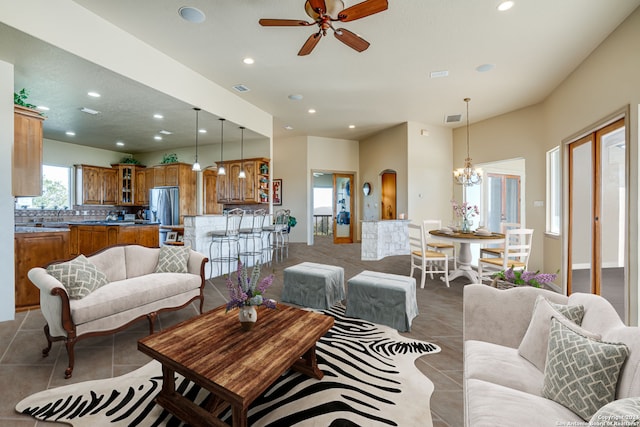 tiled living room with ceiling fan with notable chandelier