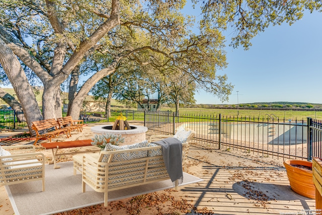 view of patio / terrace with a fire pit and a rural view