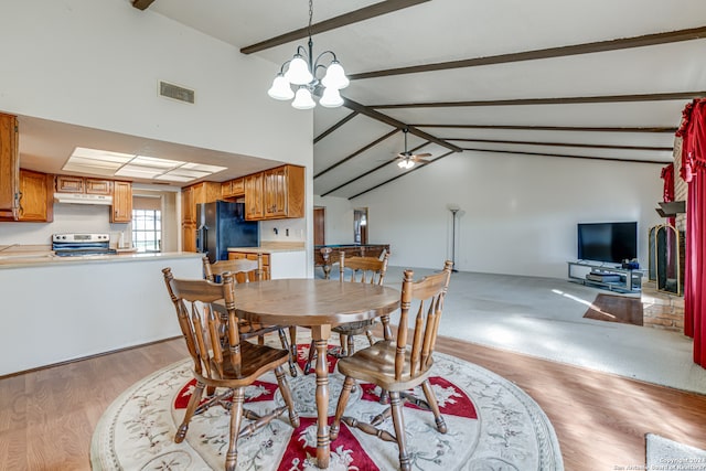 carpeted dining area featuring ceiling fan with notable chandelier and vaulted ceiling