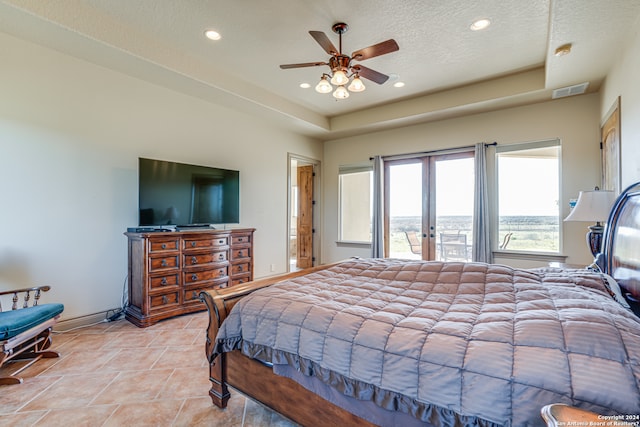 bedroom featuring french doors, light tile flooring, ceiling fan, and a tray ceiling