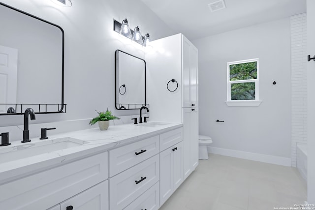 bathroom with tile flooring, double vanity, and toilet