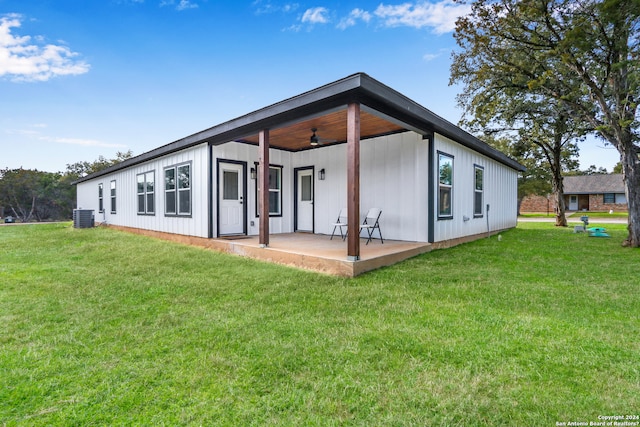 back of house with central AC unit, a yard, ceiling fan, and a patio area