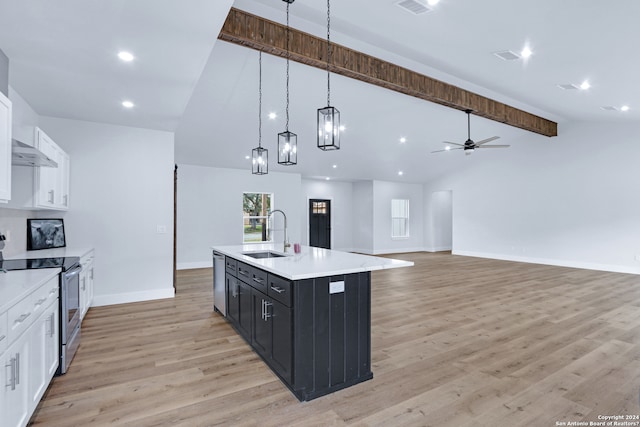 kitchen featuring electric stove, an island with sink, decorative light fixtures, ceiling fan with notable chandelier, and light wood-type flooring