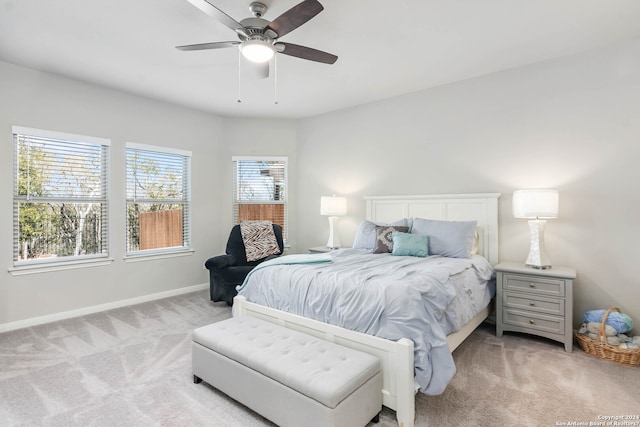 carpeted bedroom with ceiling fan and multiple windows