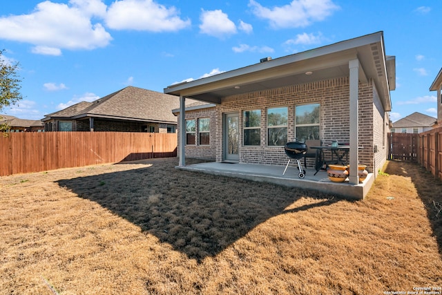 back of house featuring a lawn and a patio