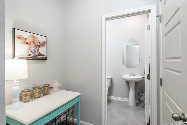 bathroom featuring tile flooring and toilet