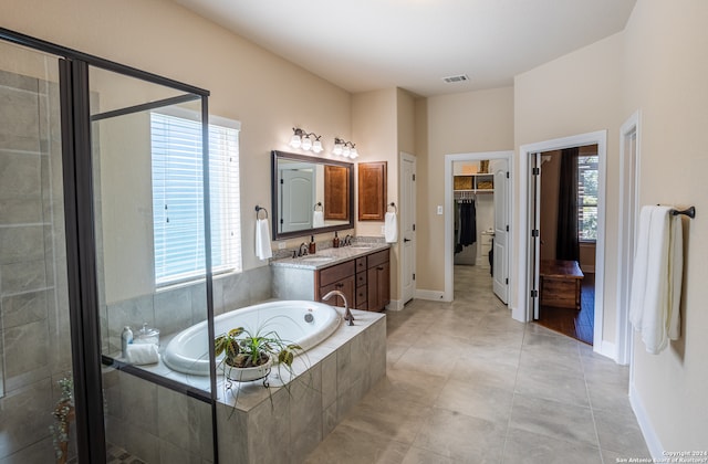 bathroom featuring tile flooring, separate shower and tub, large vanity, and a healthy amount of sunlight