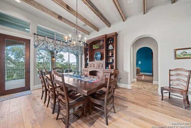 dining room featuring an inviting chandelier, beamed ceiling, and light wood-type flooring