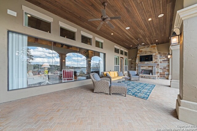 view of terrace featuring an outdoor living space with a fireplace and ceiling fan