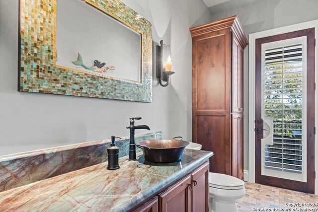 bathroom featuring vanity, tile flooring, and toilet