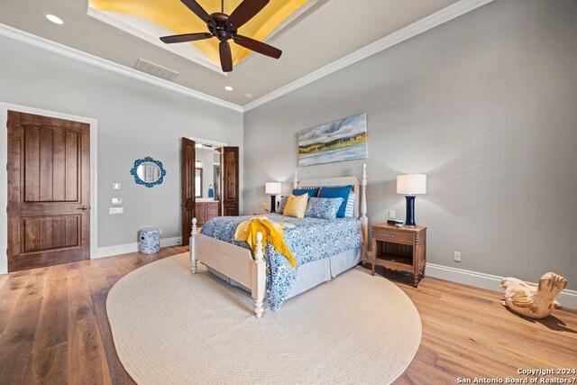 bedroom featuring ornamental molding, ceiling fan, and light wood-type flooring