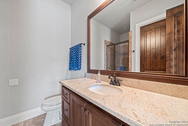 bathroom featuring tile floors, large vanity, and toilet