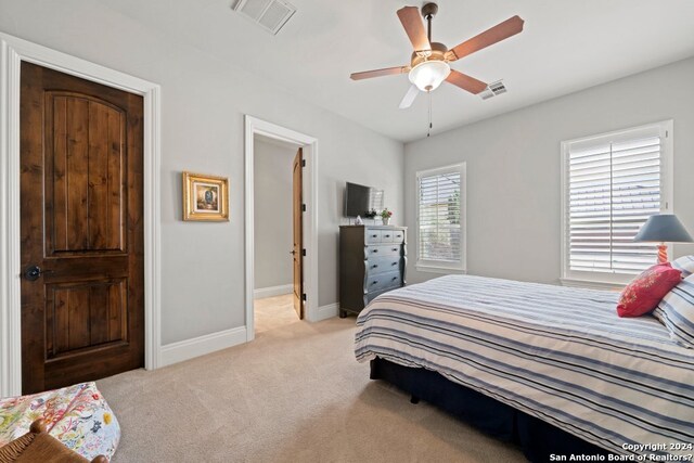 bedroom featuring light colored carpet and ceiling fan