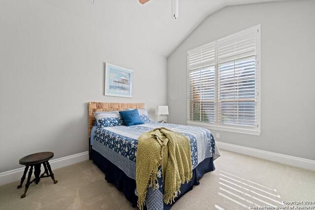 carpeted bedroom featuring lofted ceiling, ceiling fan, and multiple windows