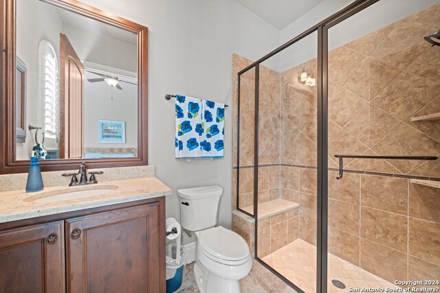 bathroom featuring a shower with door, tile flooring, oversized vanity, and toilet