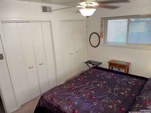 bedroom with multiple closets, ceiling fan, and carpet flooring