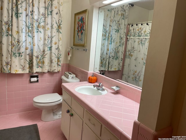 bathroom with tile walls, oversized vanity, toilet, and tile floors