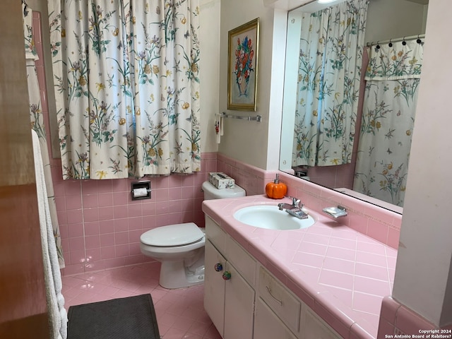 bathroom featuring tile walls, tile flooring, toilet, and oversized vanity